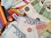 A scattered arrangement of various banknotes and credit cards, including Visa and Mastercard. The banknotes are in denominations of 1000, 2000, and 5000, featuring different colors and designs.
