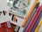A selection of various colored markers and pens is arranged next to a stack of ten thousand Hungarian forint banknotes. Several credit cards with Visa logos are visible, along with envelopes featuring orange, black, and white chevron patterns.