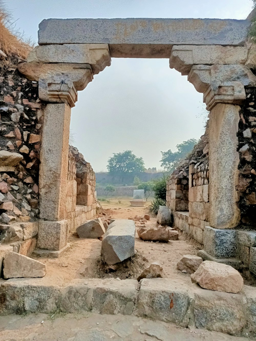 a stone arch in a stone walled area