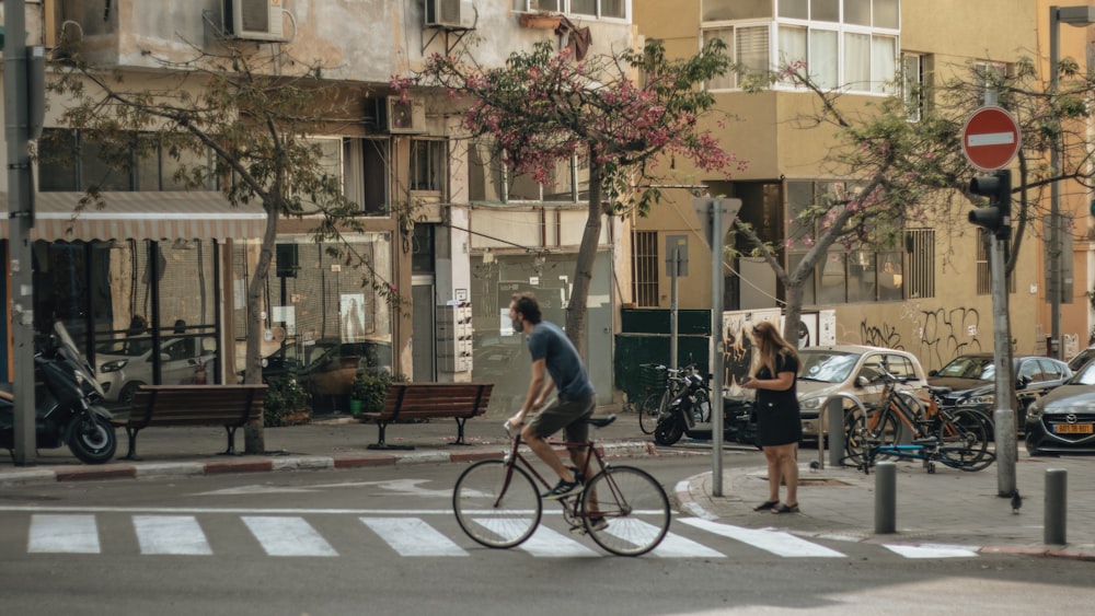 a man riding a bike down a street next to a woman