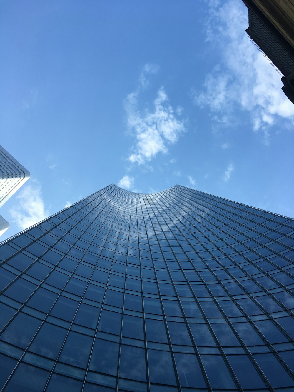 looking up at a tall building with a blue sky in the background