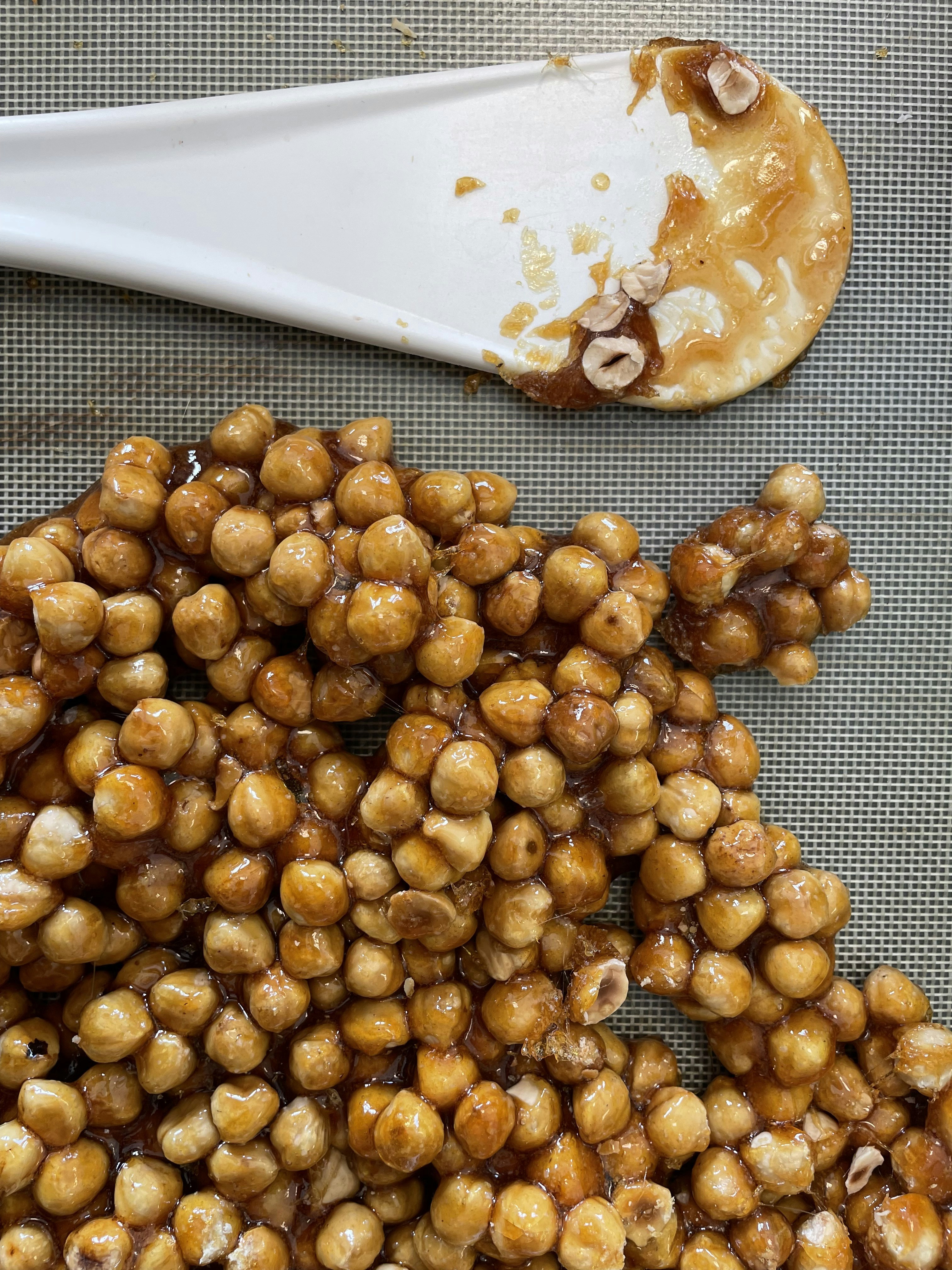 Hazelnut milk chocolate rochers with crushed nut coating on warm caramel background