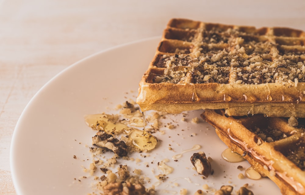 a white plate topped with waffles and nuts