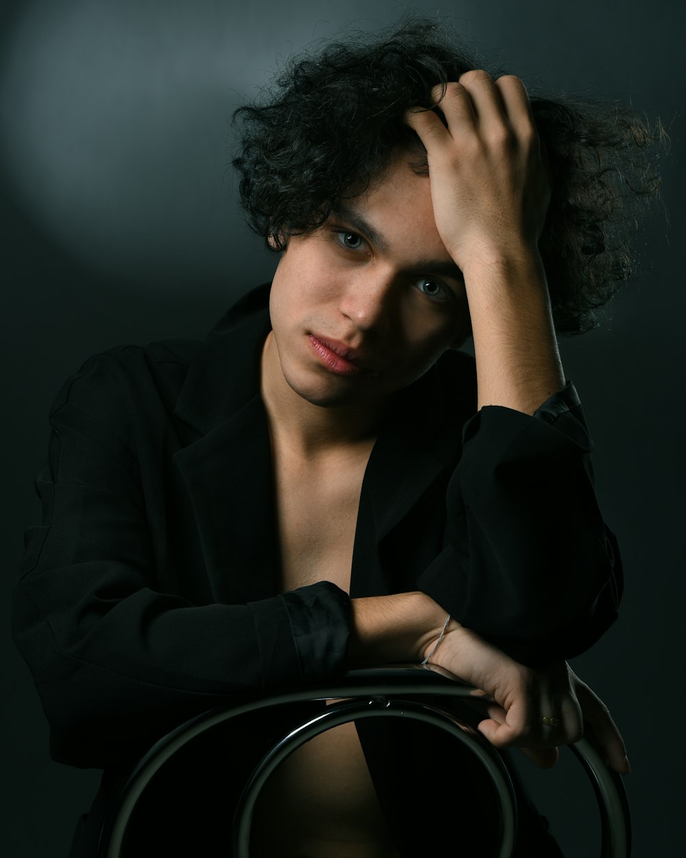 a woman sitting in a chair with her hand on her head