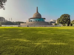 a large grassy field with a building in the background