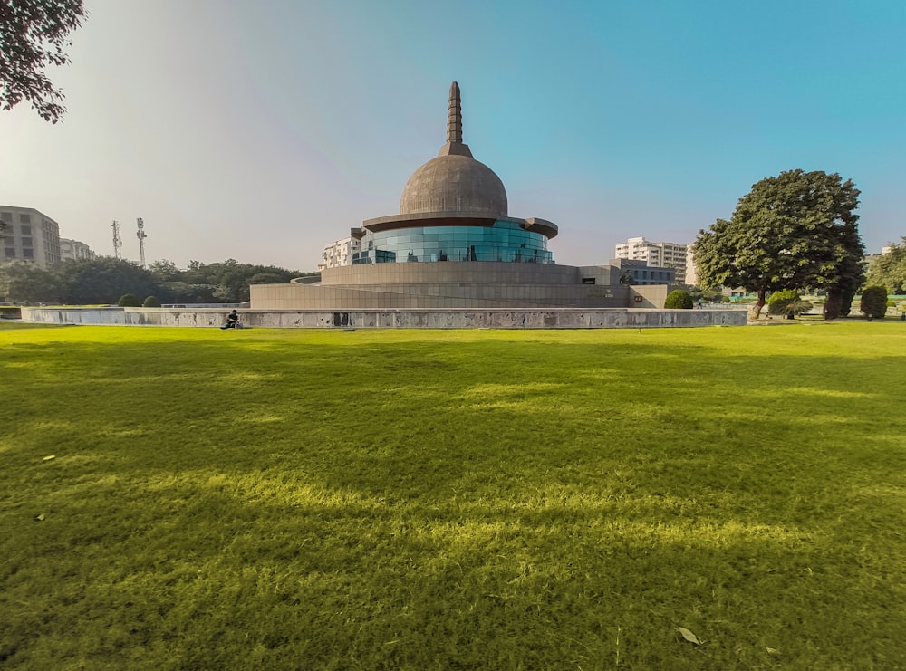 a large grassy field with a building in the background