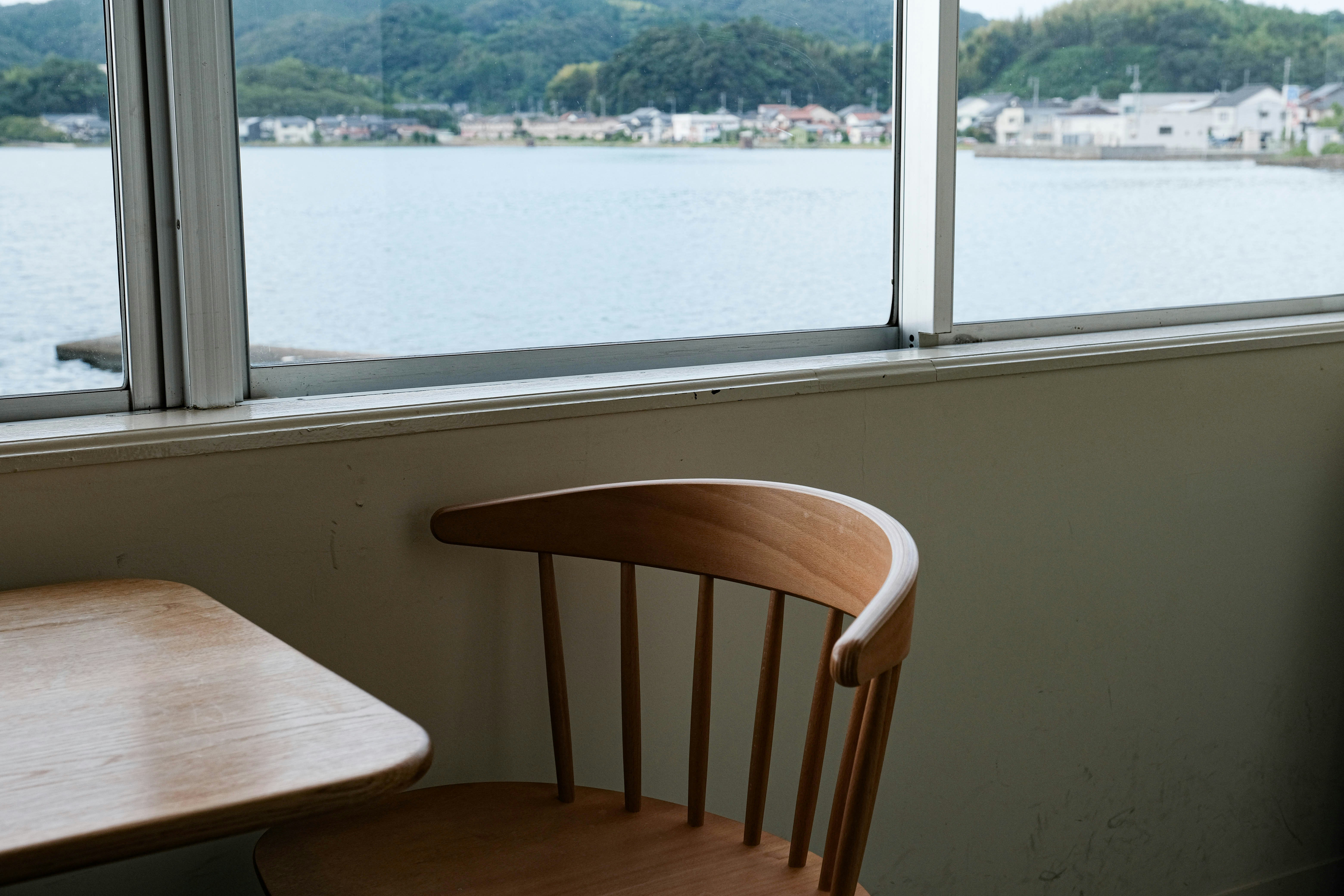 창문 앞에 앉아 있는 나무 의자