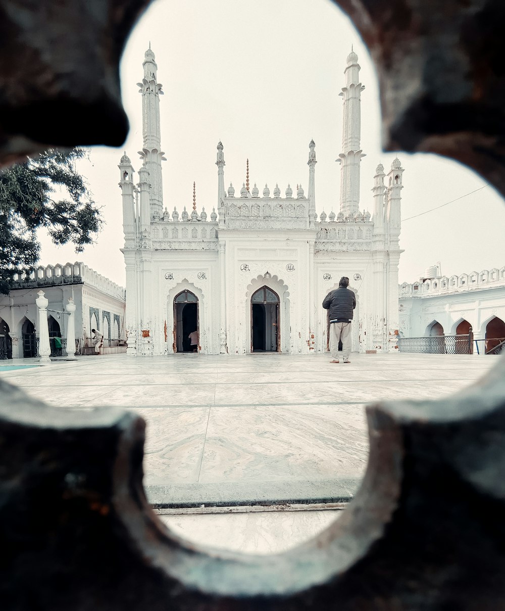 a man standing in front of a white building