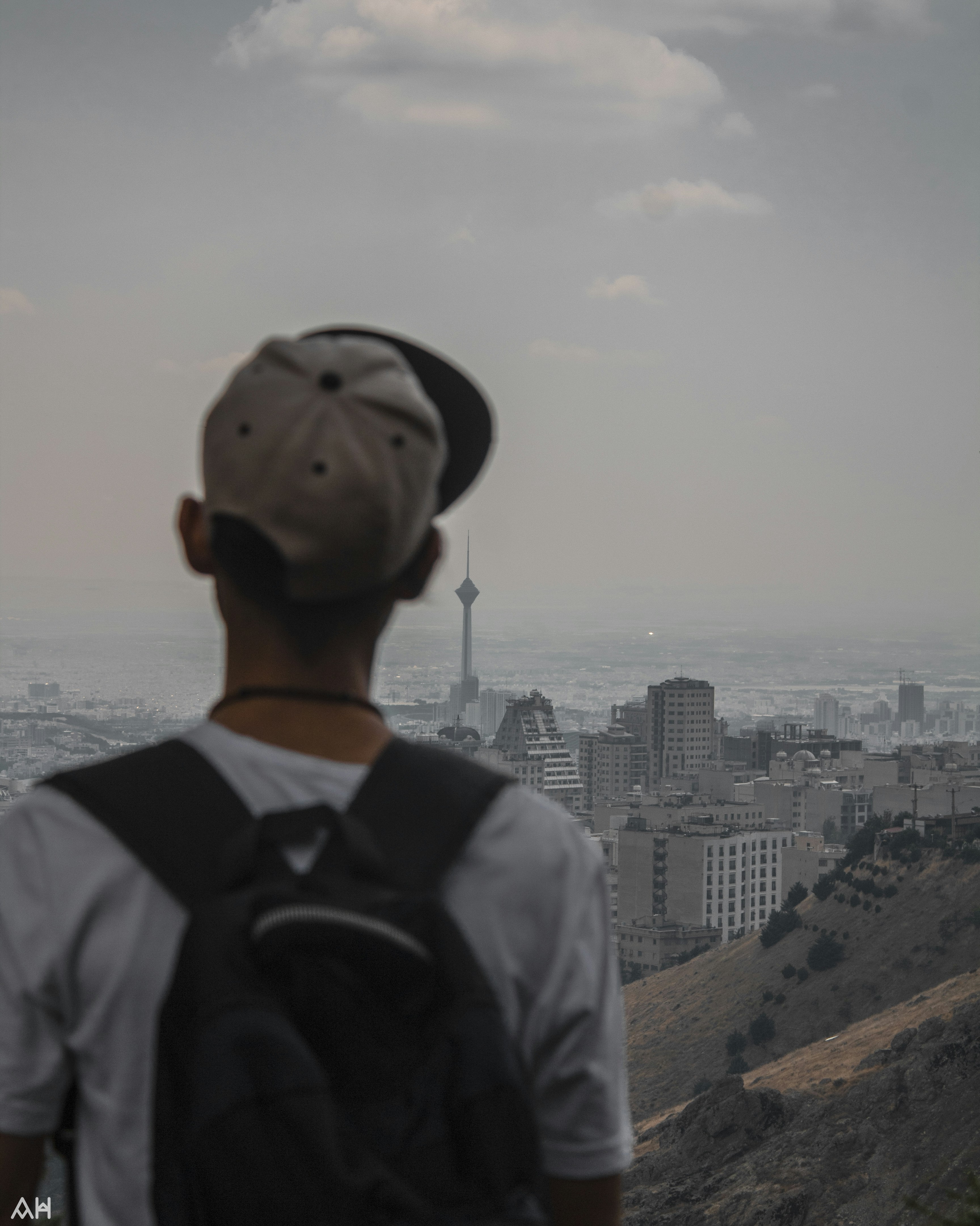 a man standing on top of a hill overlooking a city