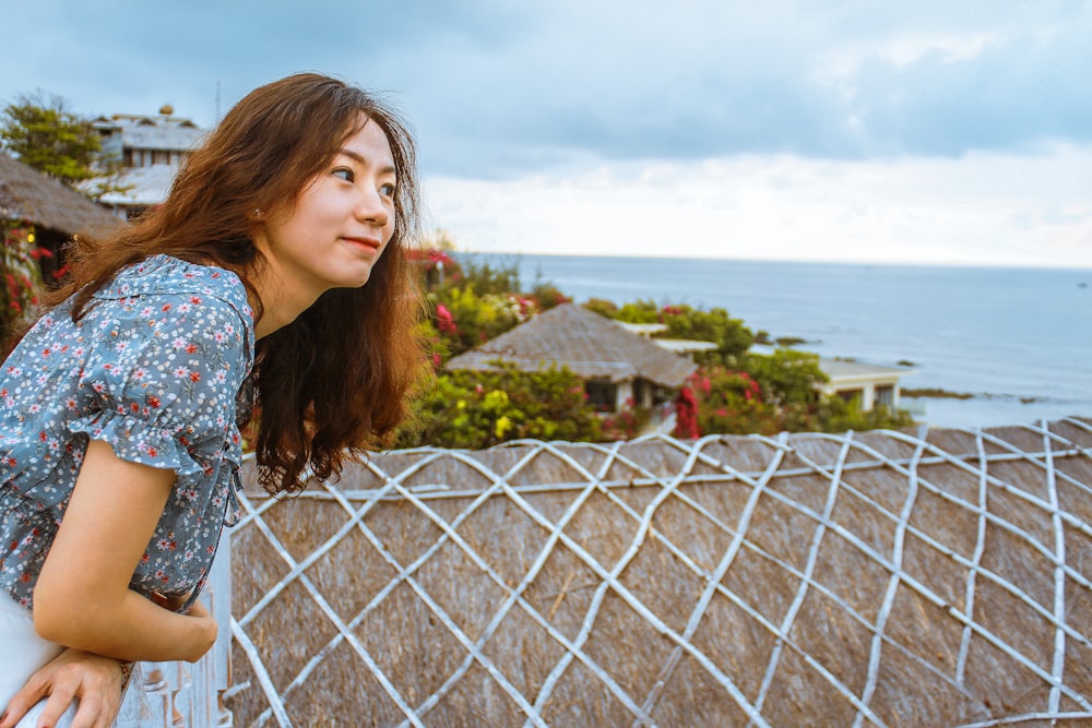 a woman standing on top of a roof next to the ocean