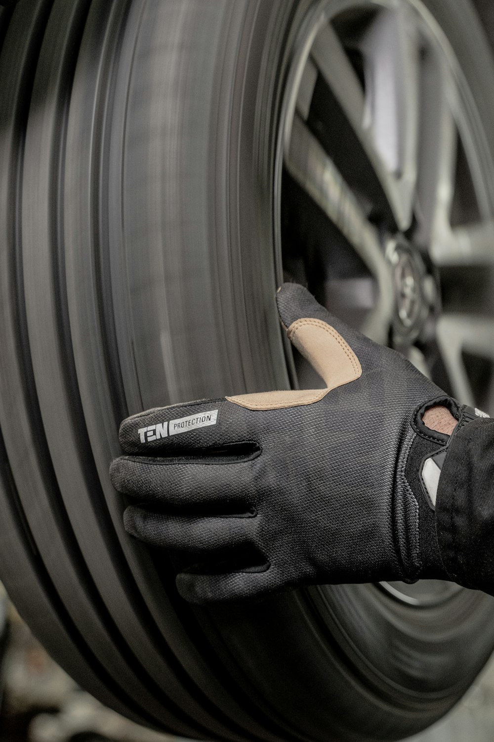 a close up of a person wearing a glove on a tire