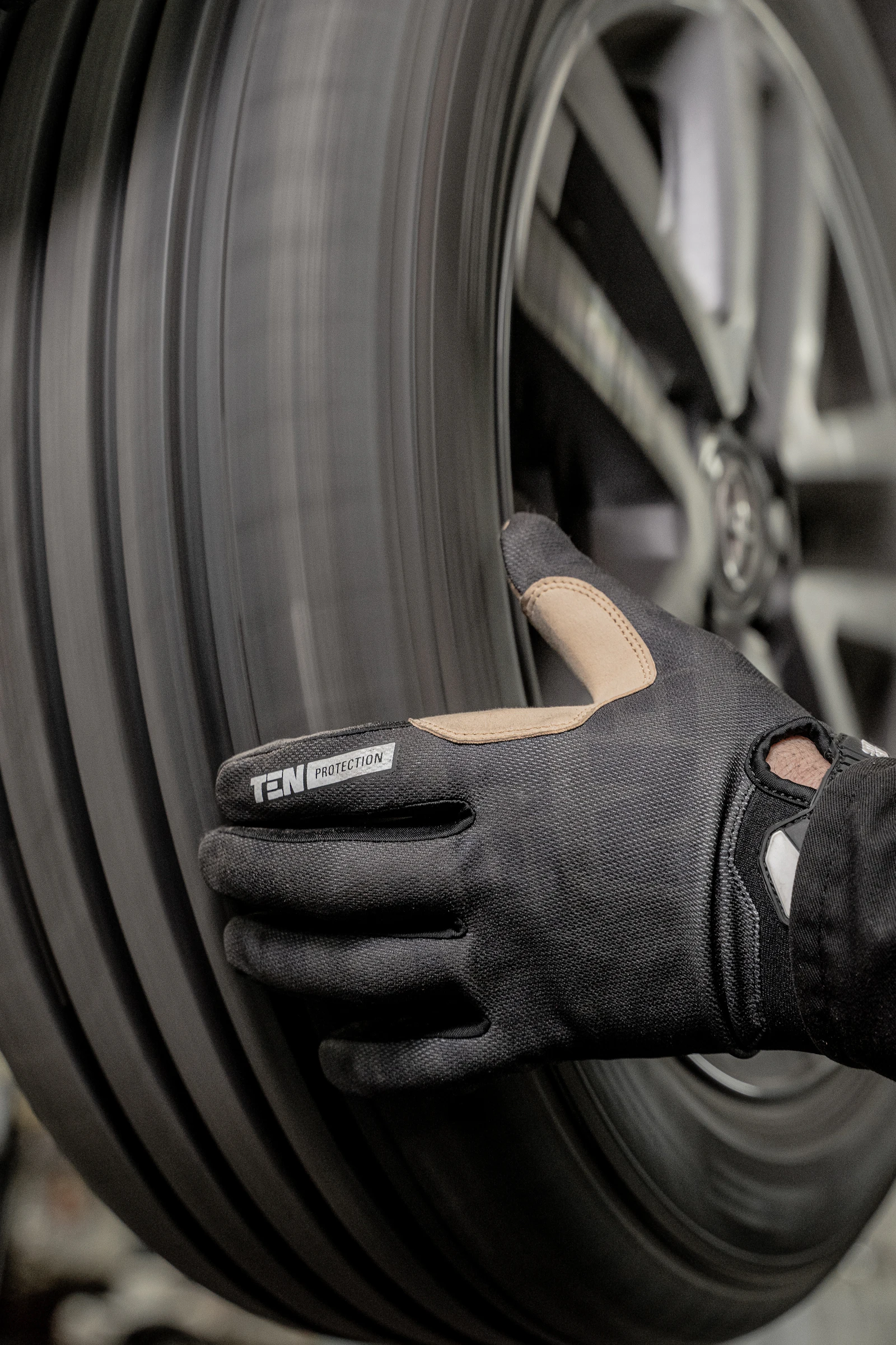 Close-up of a gloved mechanic's hand on a tire