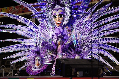 a woman in a purple costume with feathers on her head