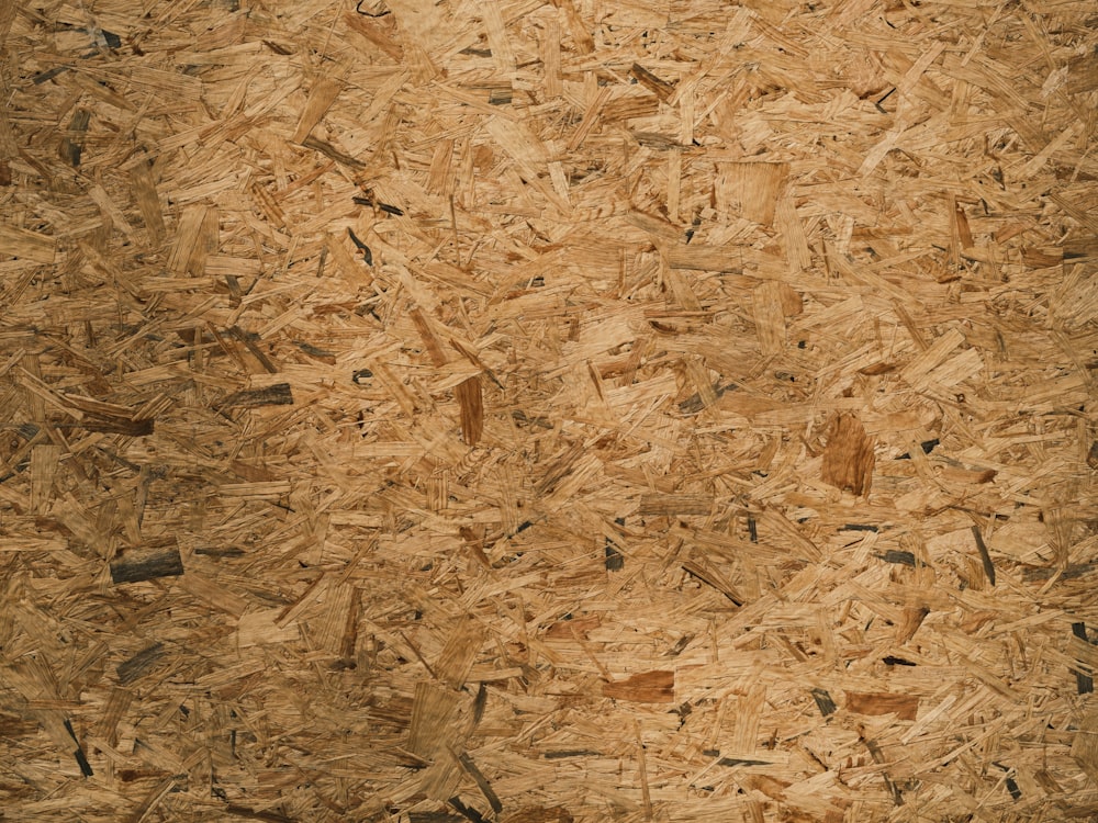 a close up of a wood board textured with wood shavings