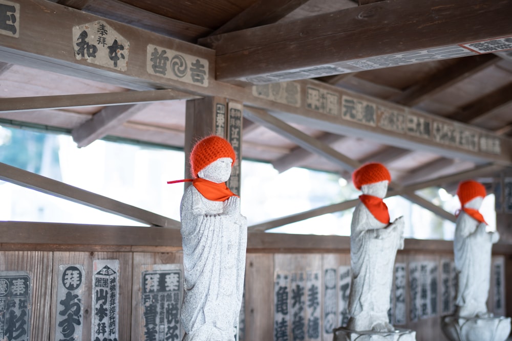 eine Gruppe von Statuen mit orangefarbenen Hüten darauf
