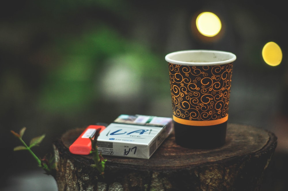 a cup of coffee sitting on top of a tree stump