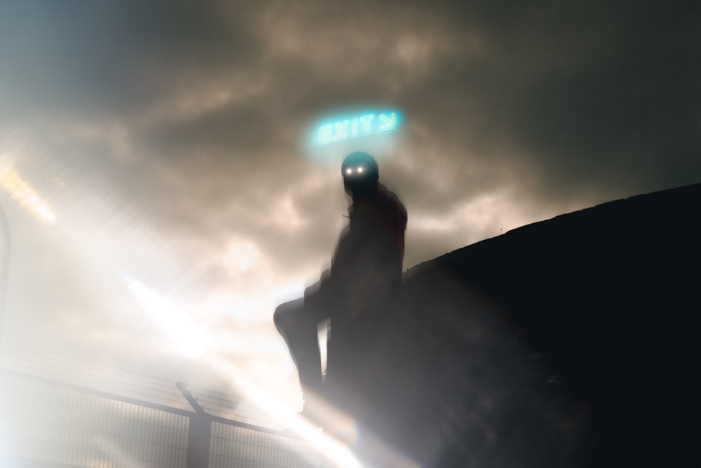 a man sitting on top of a rock under a neon sign