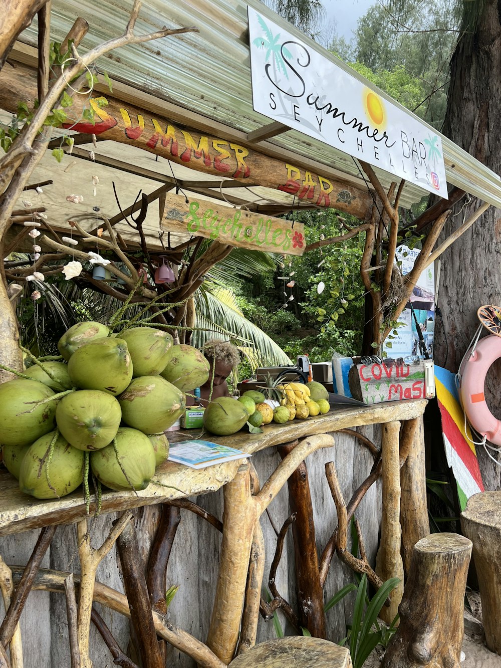 a fruit stand with coconuts, bananas, and a life preserver