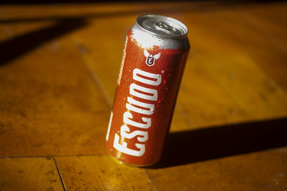 a can of soda sitting on top of a wooden table