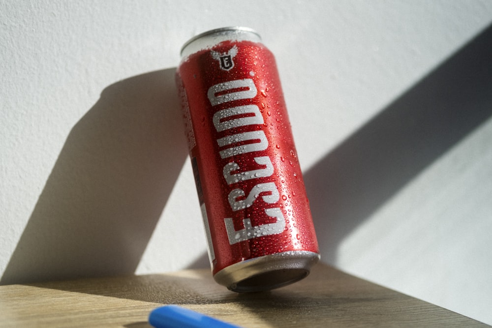 a can of soda sitting on top of a wooden table