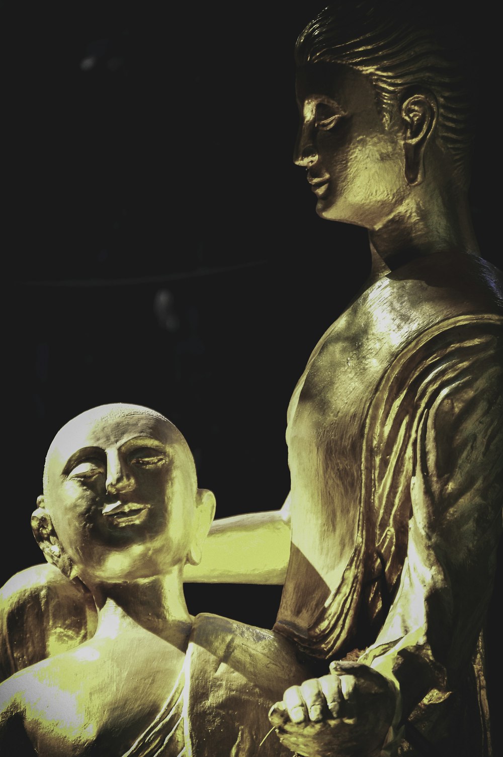 a golden statue of a man holding a baby