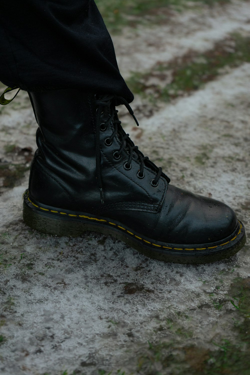 a close up of a person wearing black boots