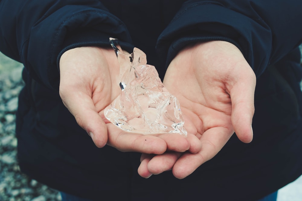 a person holding a piece of ice in their hands