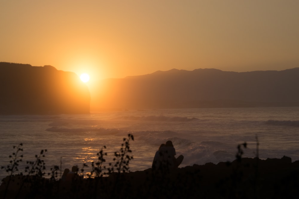 Die Sonne geht über einem Gewässer unter