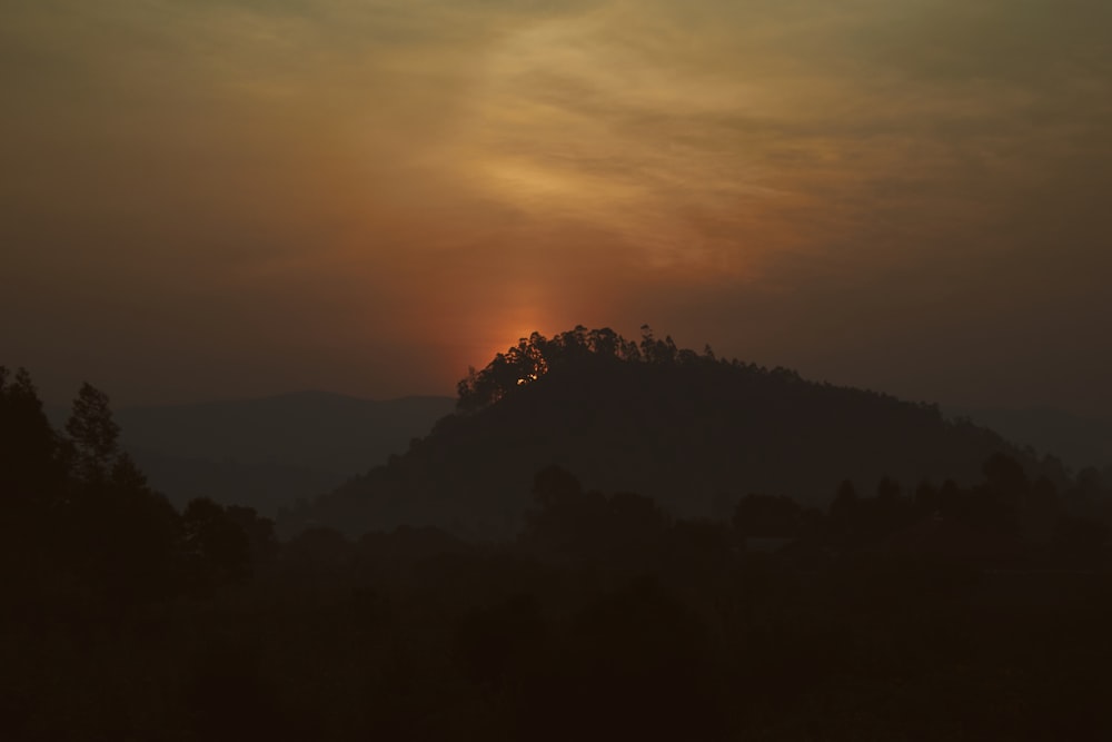 the sun is setting over a mountain range