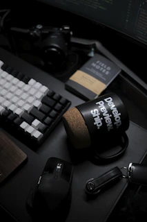 A moody desk setup featuring a typewriter, scattered pages, and a steaming cup of tea