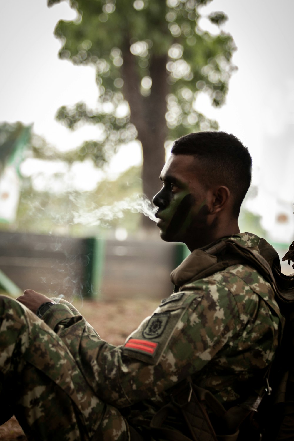 a man in camouflage smoking a cigarette