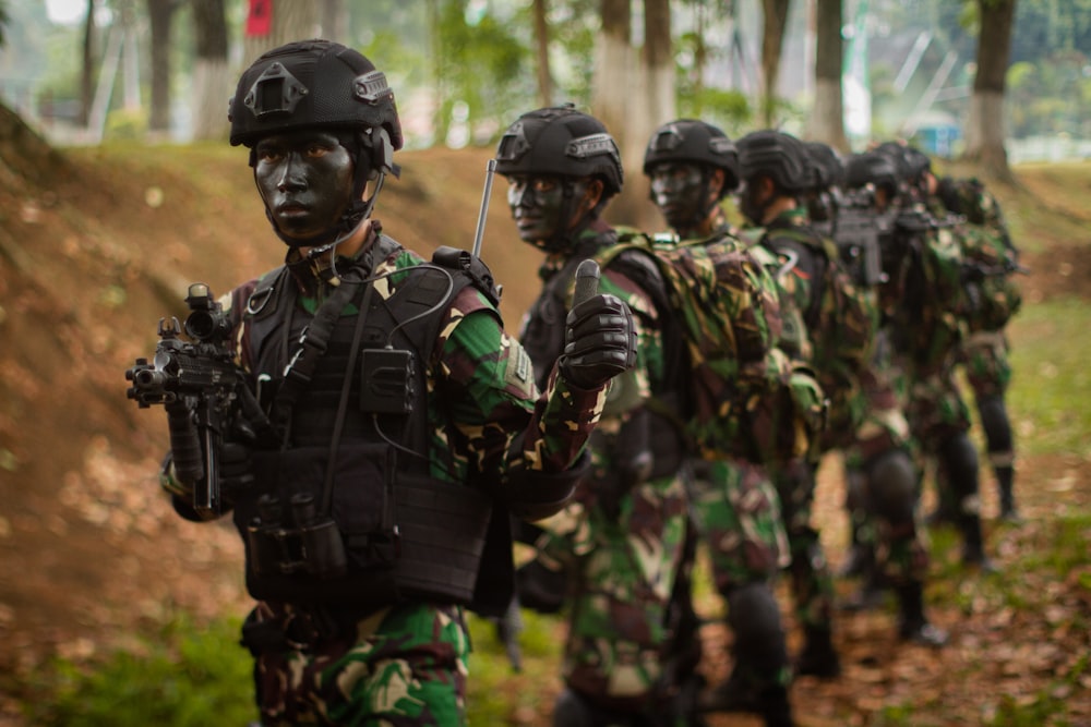 a group of soldiers walking down a dirt road