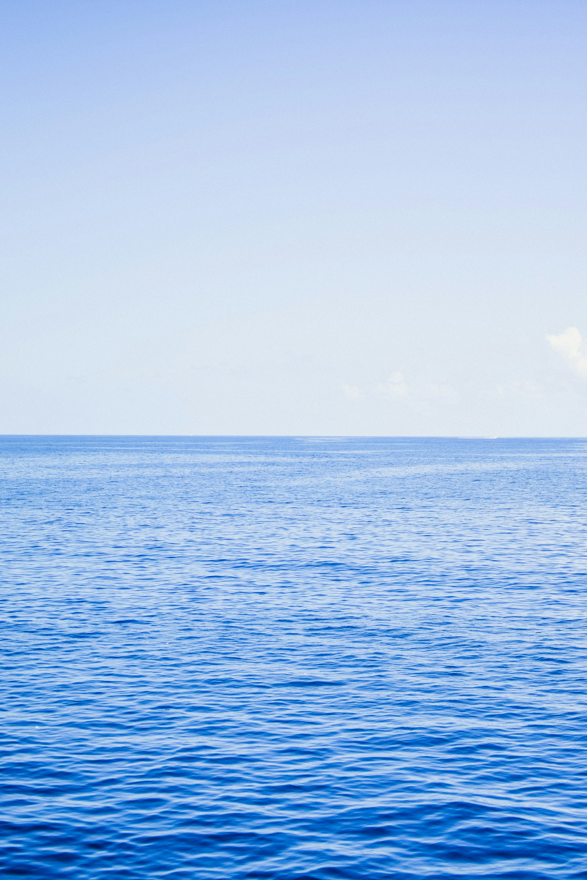 a large body of water sitting under a blue sky