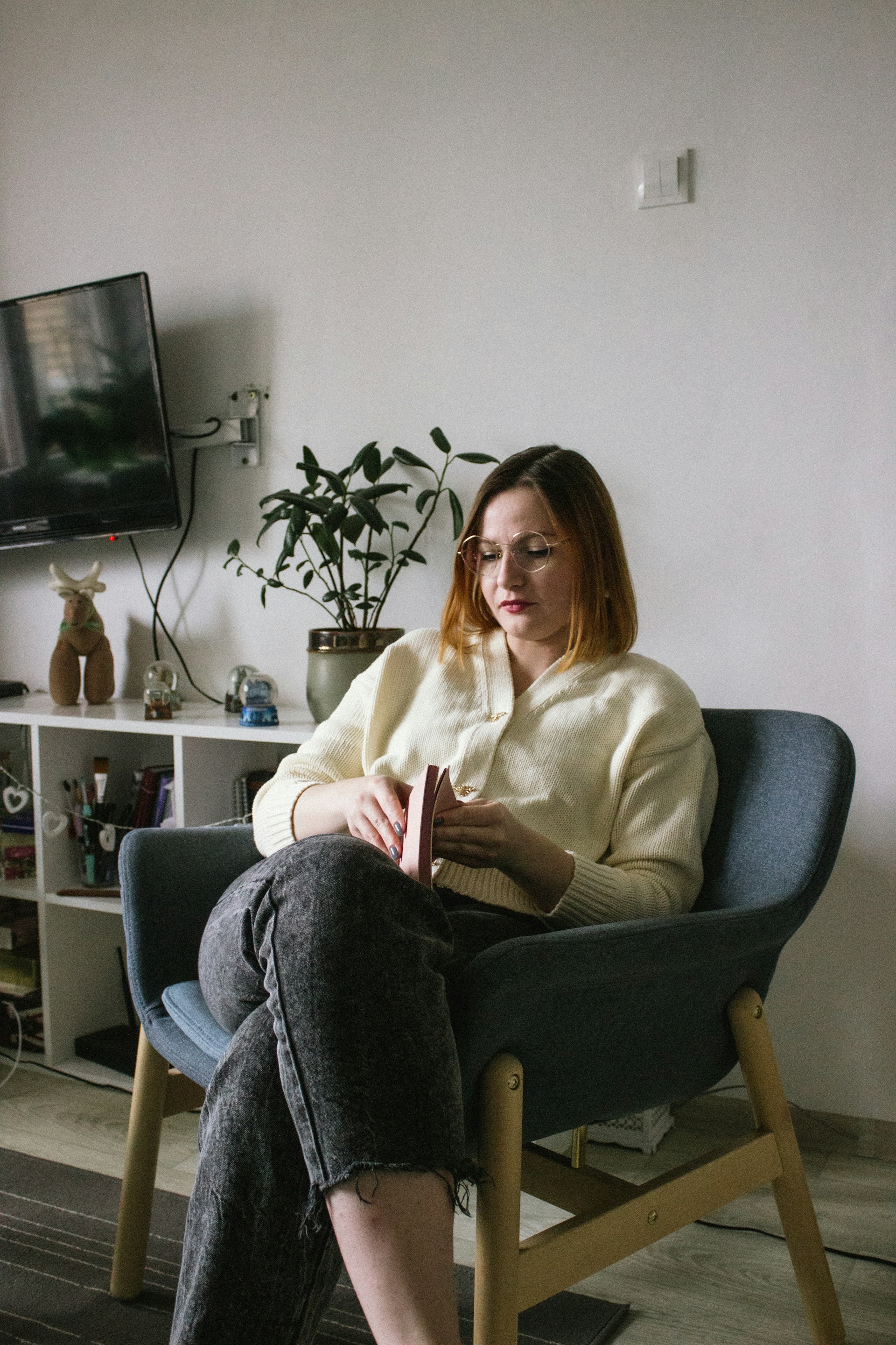 a woman sitting in a chair reading a book