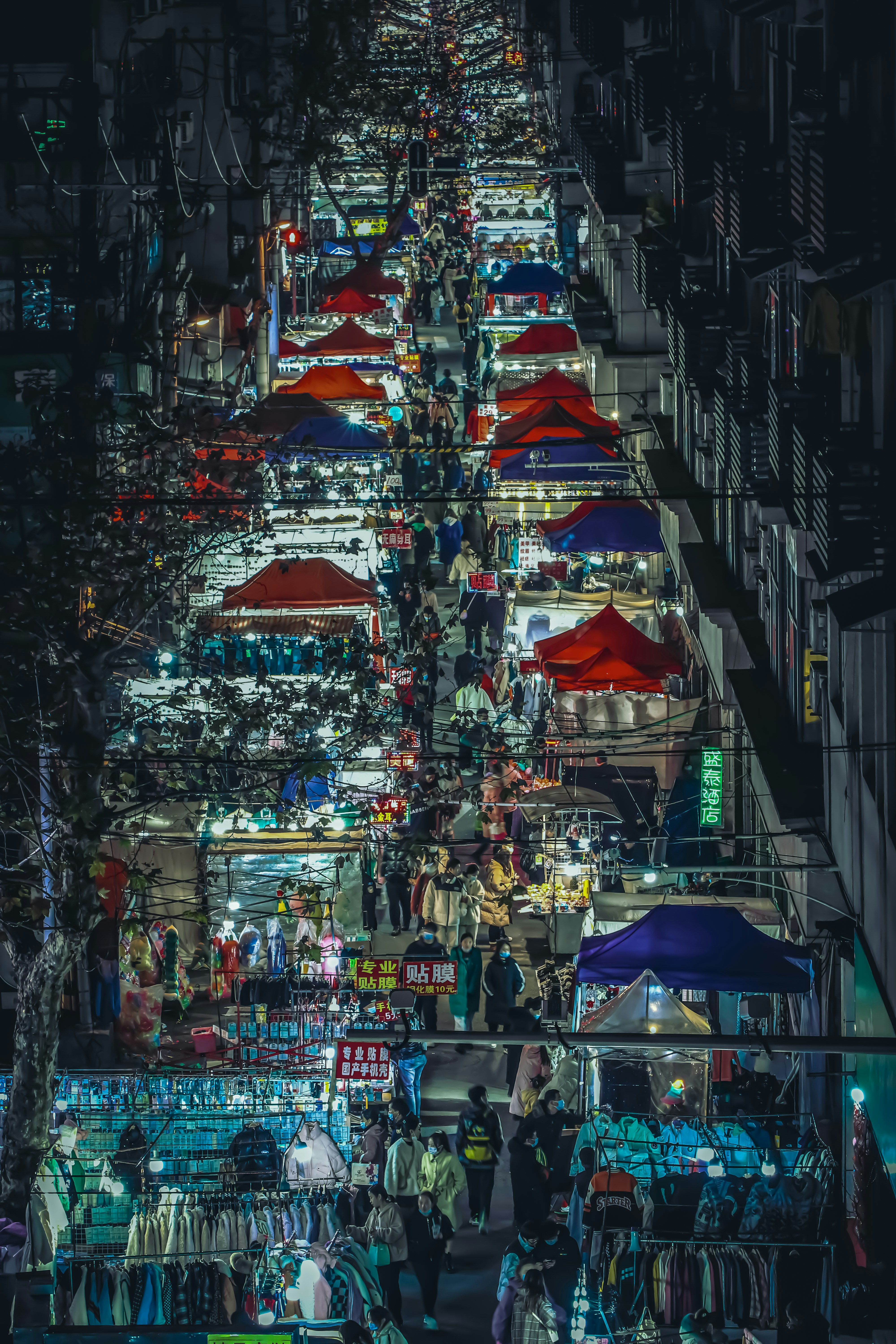 a street filled with lots of umbrellas next to tall buildings