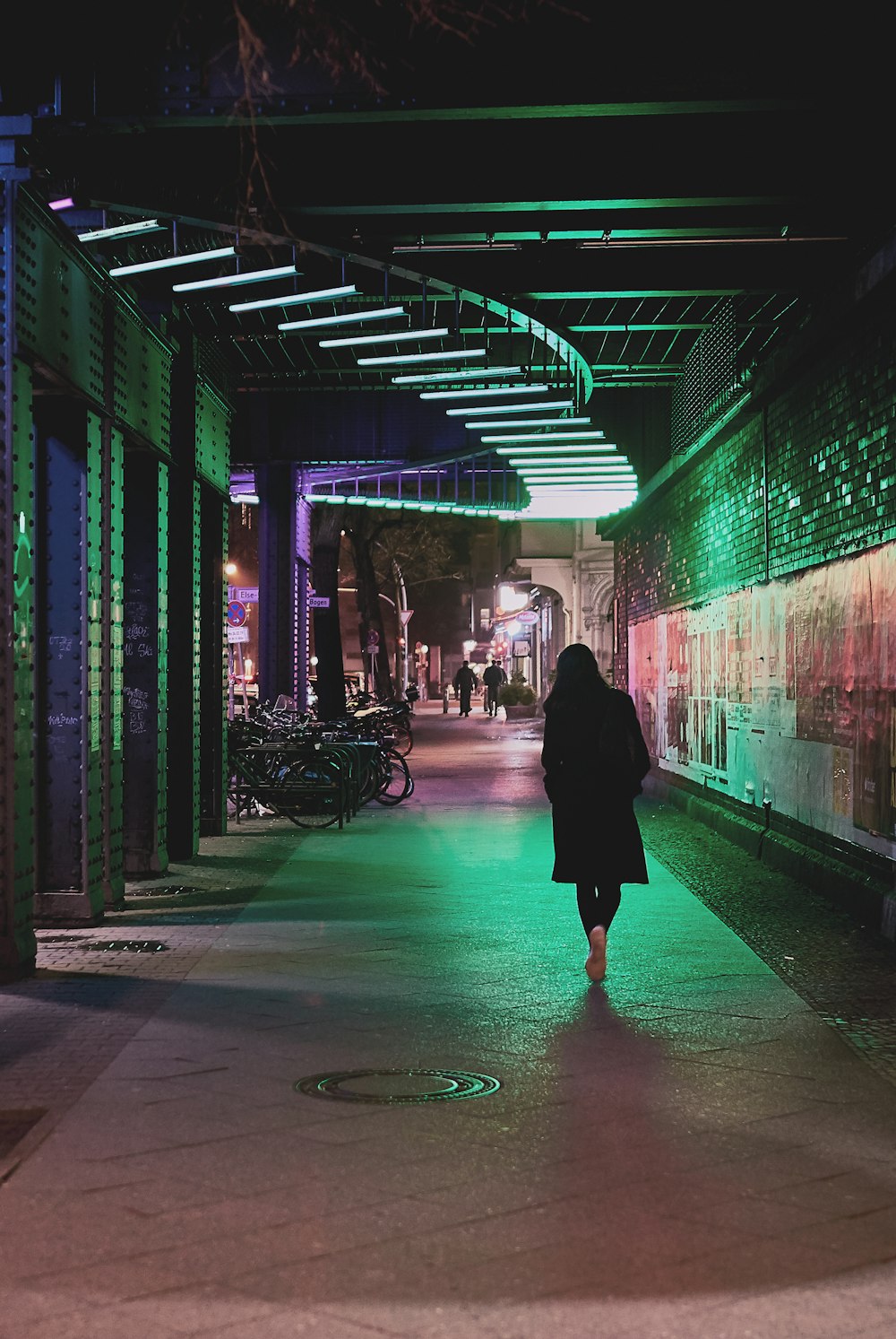 a person walking down a walkway at night