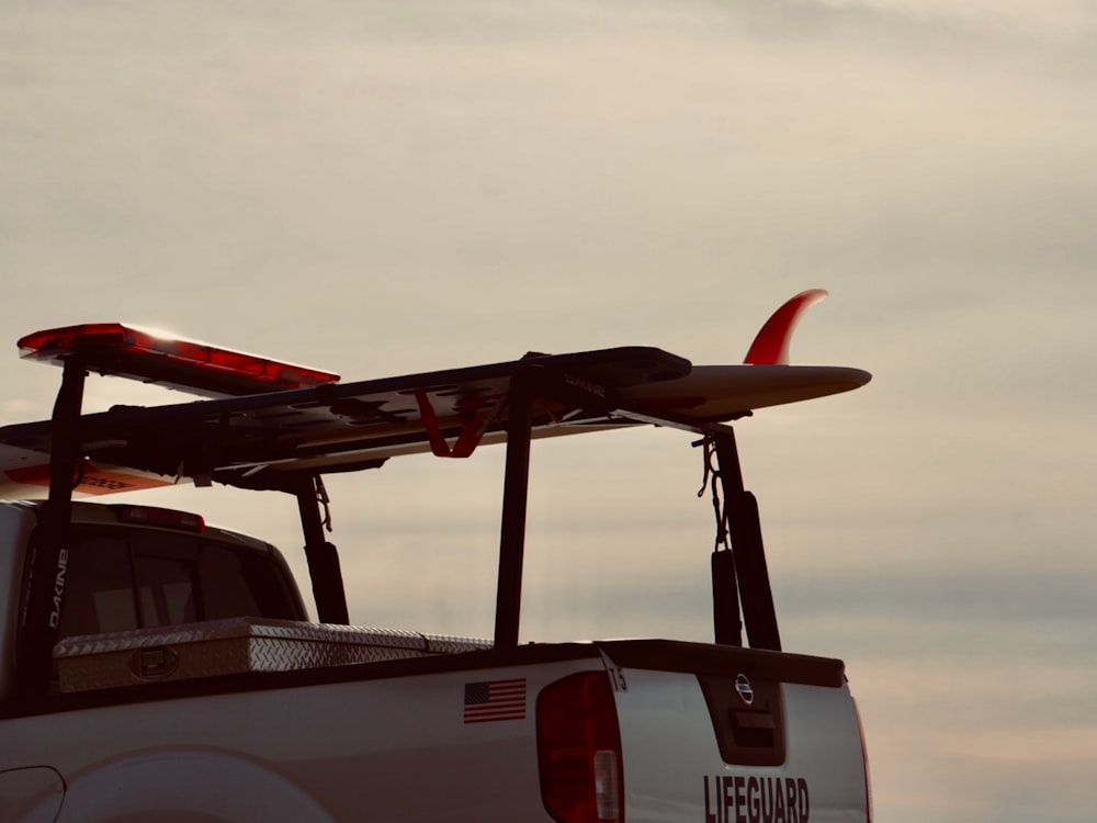 a white truck with a surfboard on top of it