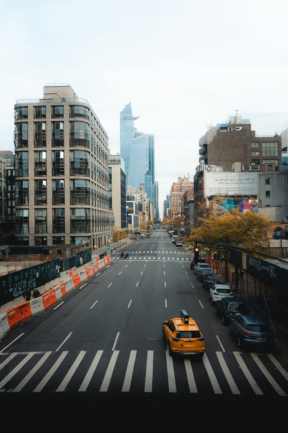 a yellow taxi driving down a street next to tall buildings