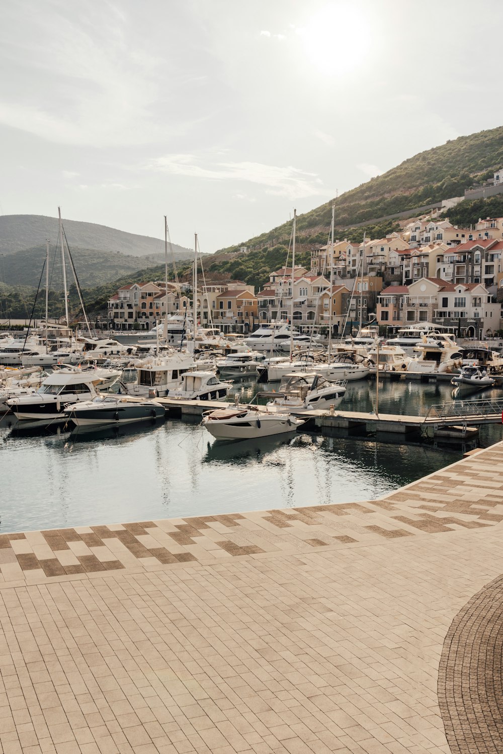 a marina filled with lots of boats next to a hillside