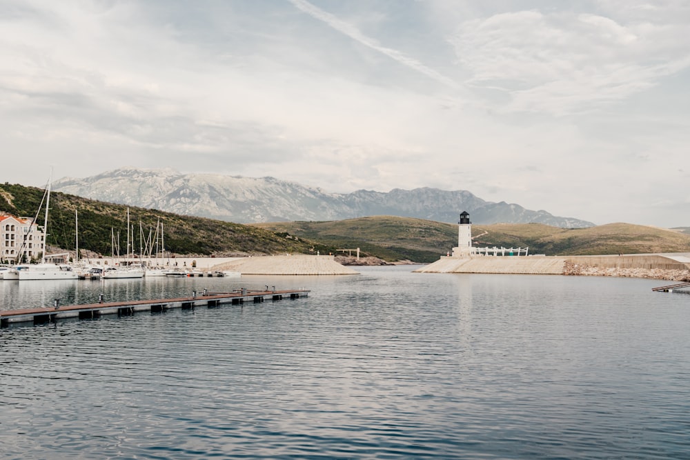 a body of water with a light house in the background