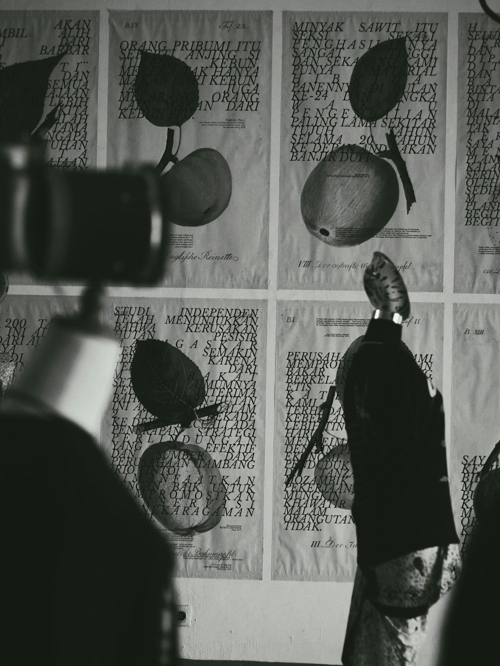 a woman standing in front of a wall covered in paper