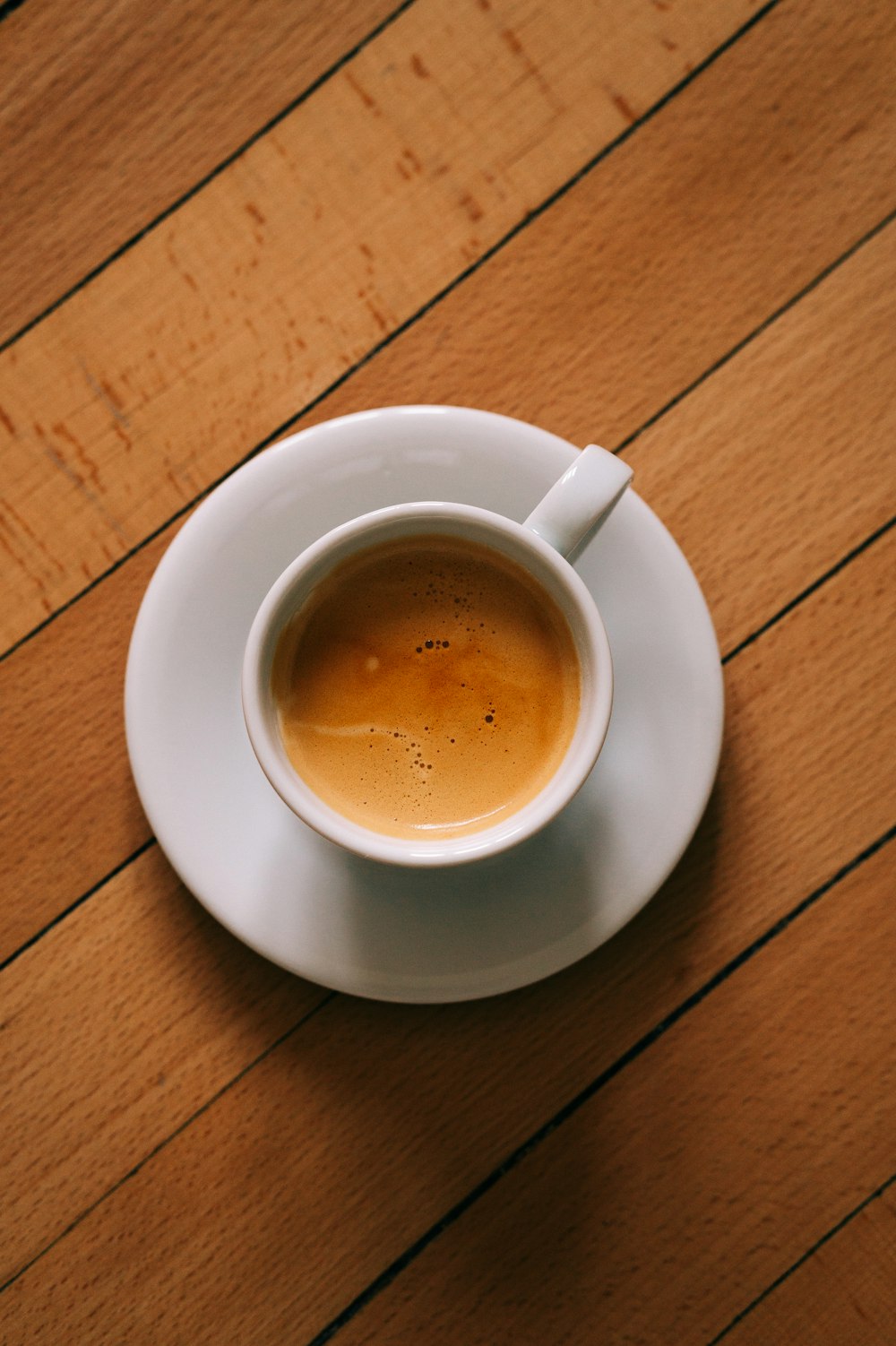 a cup of coffee sitting on top of a white saucer