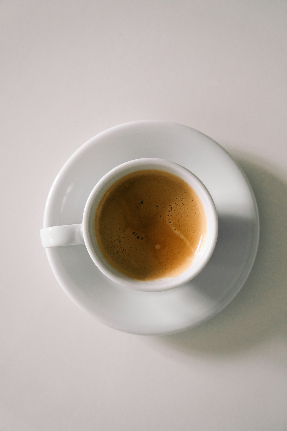 a cup of coffee sitting on top of a white saucer