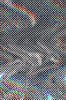 A pattern of regularly spaced black circles on a white background with colorful areas including shades of cyan, magenta, yellow, and blue, creating a halftone effect.