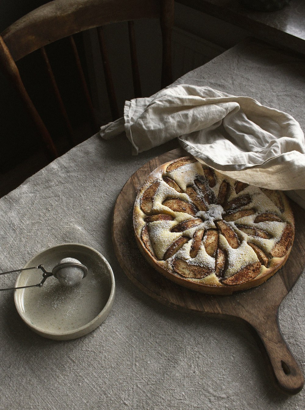 a pastry on a wooden board next to a bowl