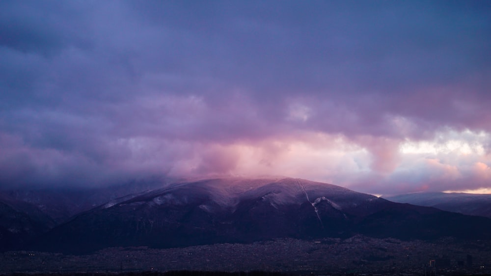 a view of a mountain range with clouds in the sky