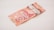 A Canadian 50-dollar bill is resting on a light-colored surface. The note is primarily red and features intricate designs, including a portrait of a historical figure.
