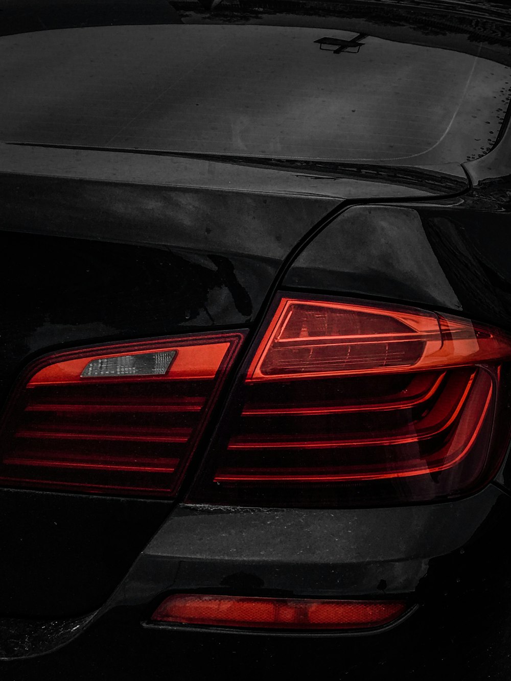 A close up of the tail lights of a black car photo – Free Light Image on  Unsplash