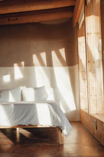 Comfortable bedroom with soft linens and natural sunlight.