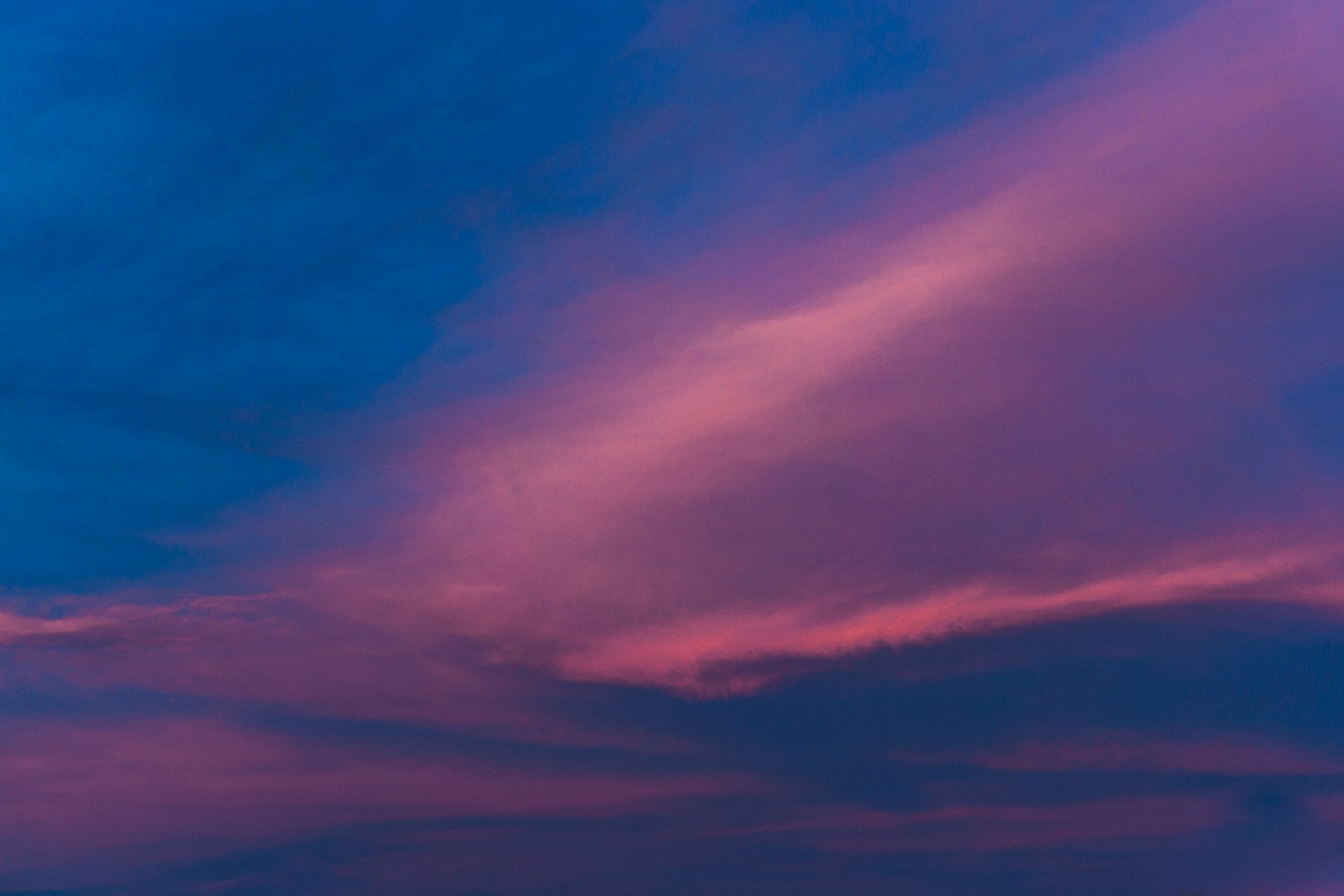 a plane flying in the sky at sunset